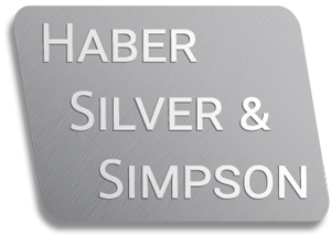A metallic gray business card with embossed text reading 