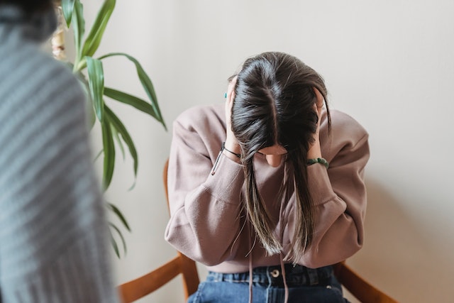 woman clutching head in hands