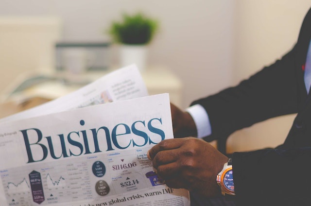 man in suit reading business newspaper