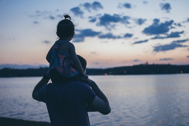 man standing with baby on his shoulders