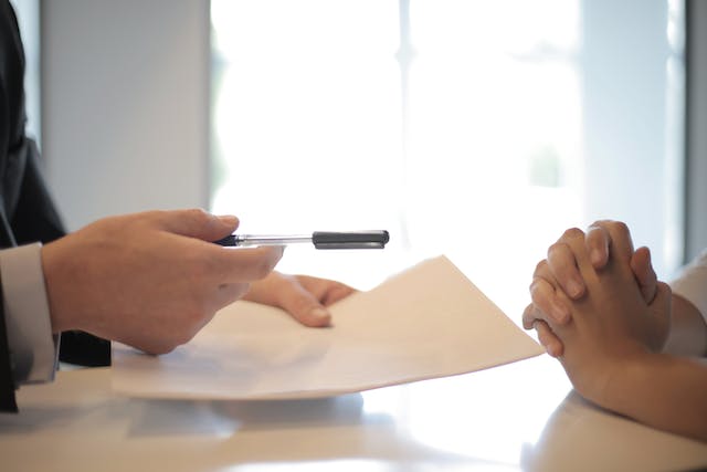 person holding pen and paper