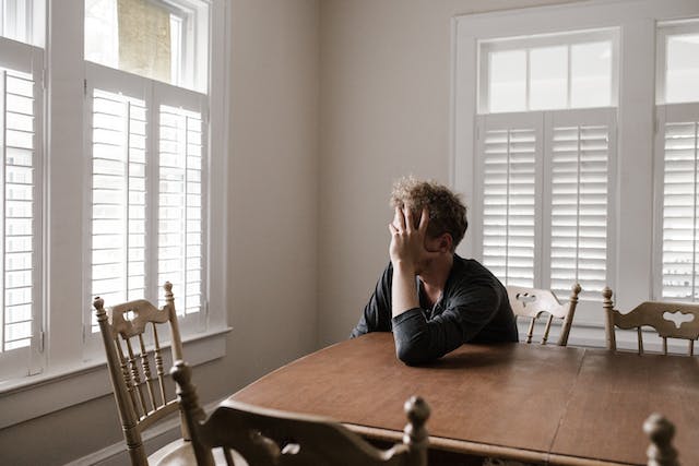 sad man sitting at table alone