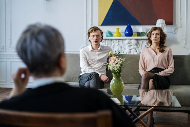 couple sitting on couch across from another person