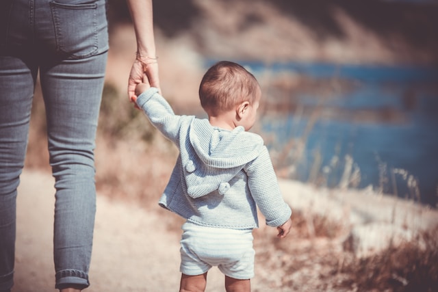 woman holding hand of child