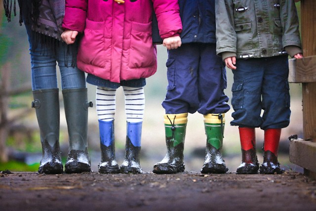 children standing with rainboots