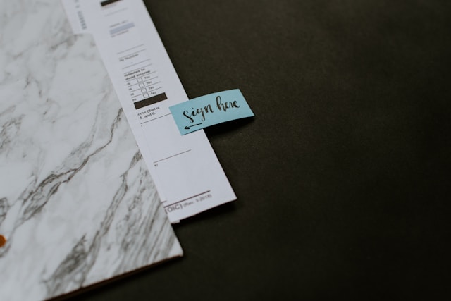 paper in folder with sign here tab