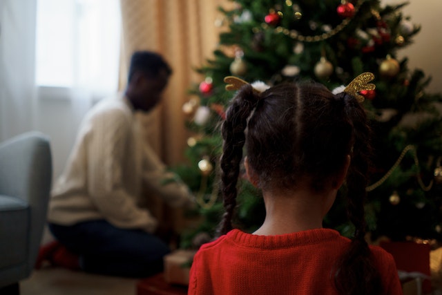 child in front of christmas tree