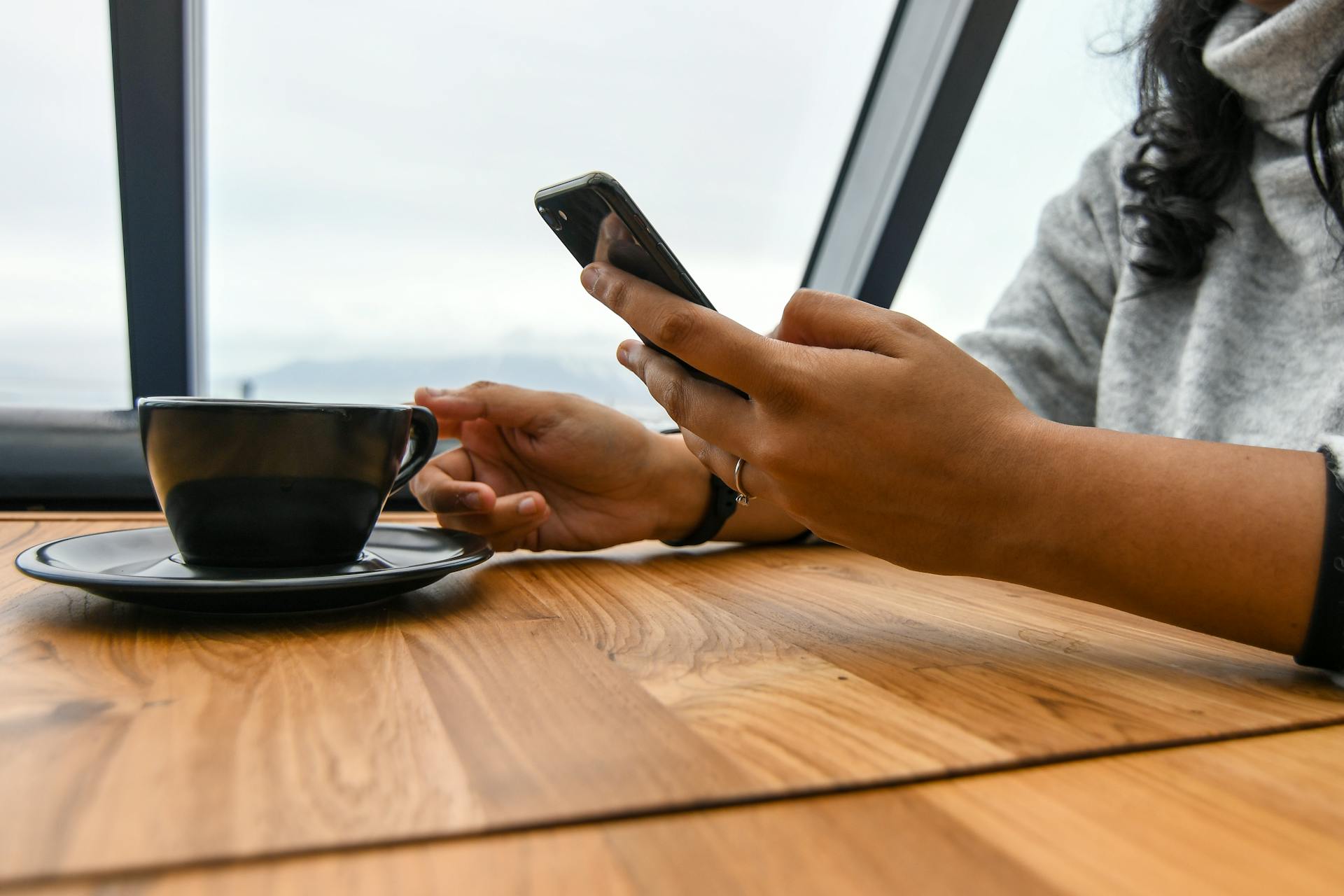 woman texting while drinking coffee